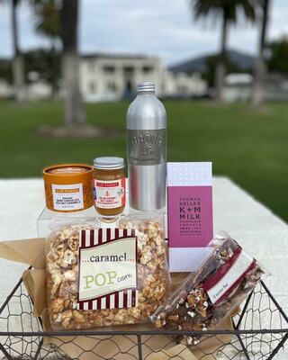 basket with chocolates, popcorn and jars of sweets