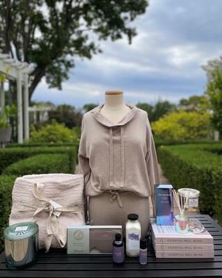 table with books, candles, eye masks, and cozy lounge wear