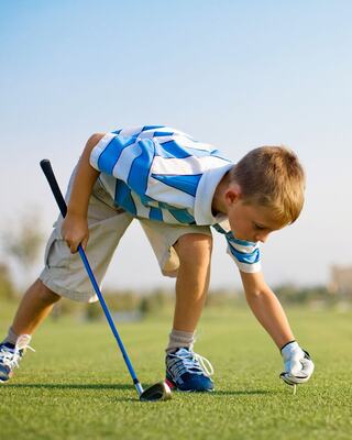 Young boy placing his golf tee