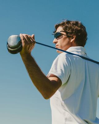 Male Golfer with Sunglasses on Holding Golf Club Resting on his Shoulders