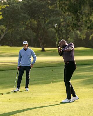 Two Men Golfing with One Swinging his Club