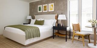 Hotel Room with a Bed, Furniture, and Bottle of Wine in Napa