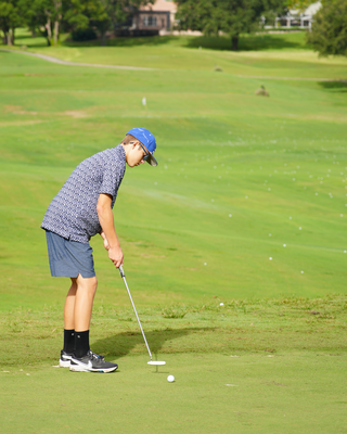 Boy playing golf on golf course