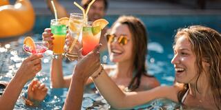 Friends in pool with cocktails