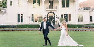 Bride and groom walking across the Mansion Lawn