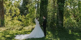 Bride and groom looking into each others eyes in nature surrounded by many trees
