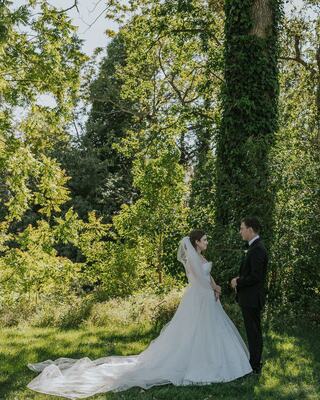 Bride and groom looking into each others eyes in nature surrounded by many trees