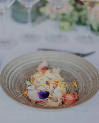 Fancy plated food topped with flowers on a table