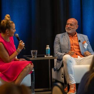 panel leader asks panelist a question during a conference