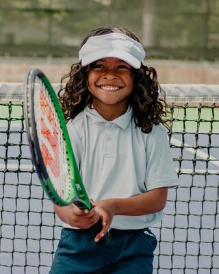 A Young Boy Hold a Tennis Racquet on a Tennis Court