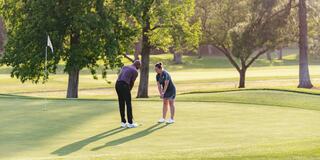 man and women on the putting green