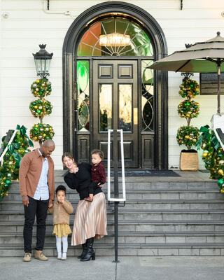 family on the lobby steps decorated for the holidays