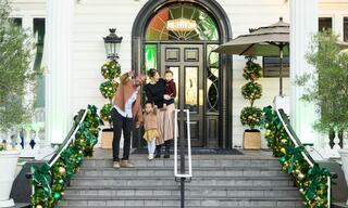 family on the lobby steps decorated for the holidays