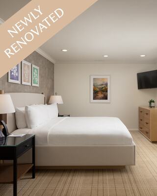 Hotel Room with a Bed, Furniture, and Bottle of Wine in Napa