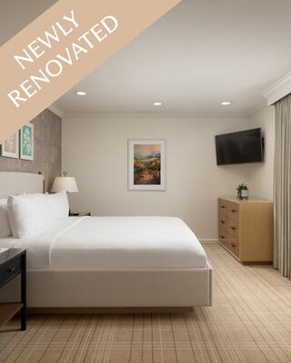 A Studio Hotel Room with Dresser, TV and Bed