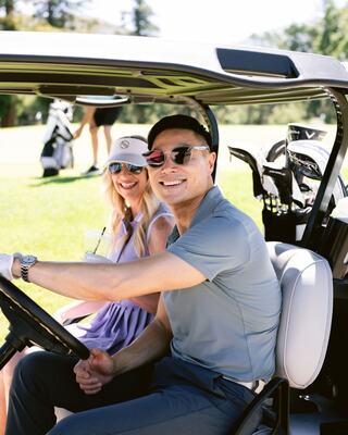 man and woman in a golf cart