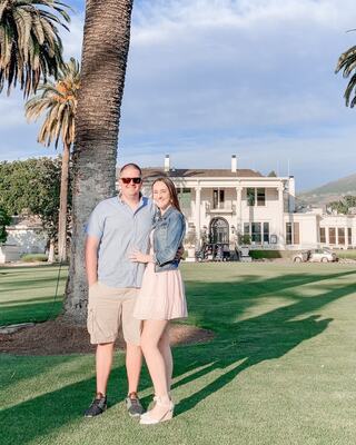 couple standing under a palm tree with sunlight streaming across them