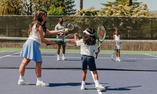 Family playing tennis on the Silverado racquet sports court