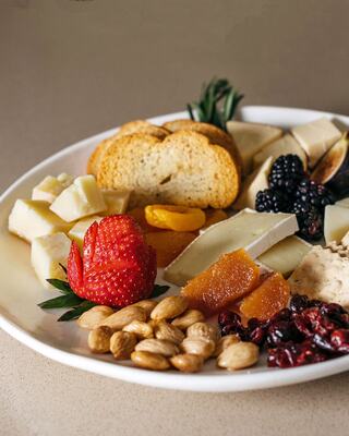 A Charcuterie Plate of Cheeses, Nuts, Bread, and Dried Fruit