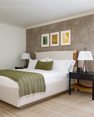 Hotel Room with a Bed, Furniture, and Bottle of Wine in Napa