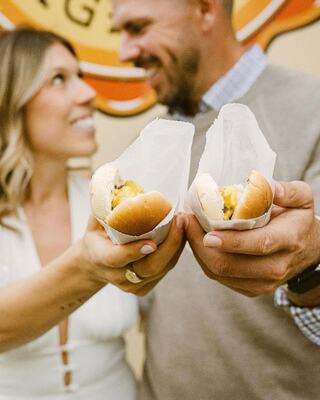 Couple Holding Burgerdog Food Smiling at Each Other