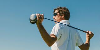 Male Golfer with Sunglasses on Holding Golf Club Resting on his Shoulders