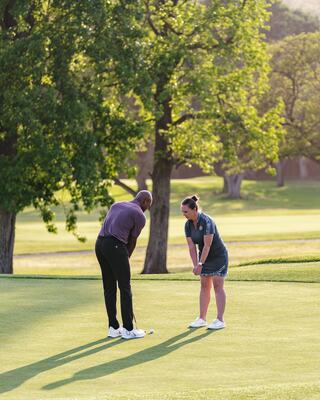 Female Golfer Taking Golf Lessons from a Male Golf Instructor