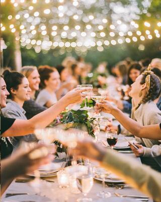 Women Enjoying Drinks at an Outdoors Celebration at a Table