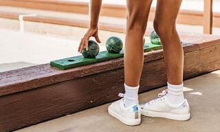 Young Girl Picking Up Balls on a Bocce Court