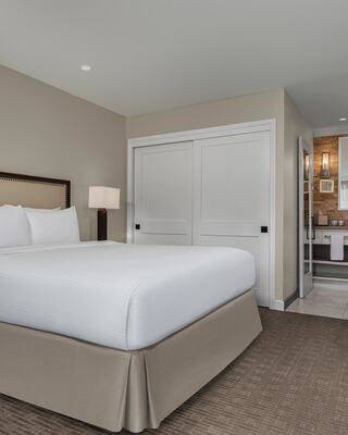 A Modern Hotel Room with a Bed, Closet, and Bathroom in Napa