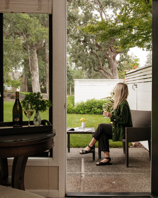 Woman with a Glass of Wine on Sitting on a Chair on an Outdoor Patio