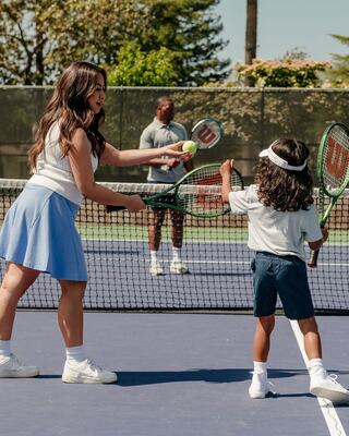 A Family Playing Tennis on a Tennis Court