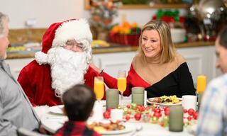 Family around a table enjoying breakfast with Santa